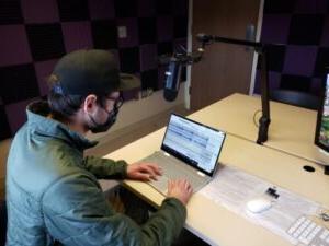 Student editing audio files on a computer 